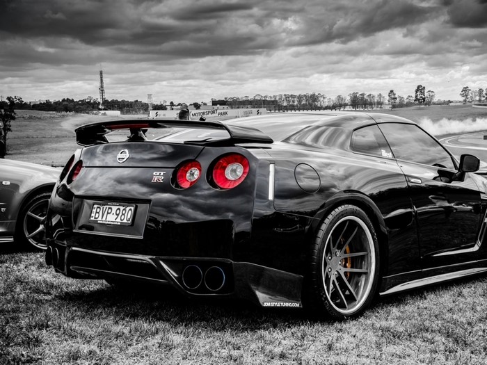 Black Nissan GT-R with selective coloring on a track