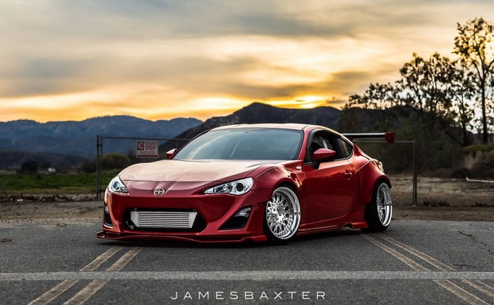 Red Scion FR-S sports car with custom wheels