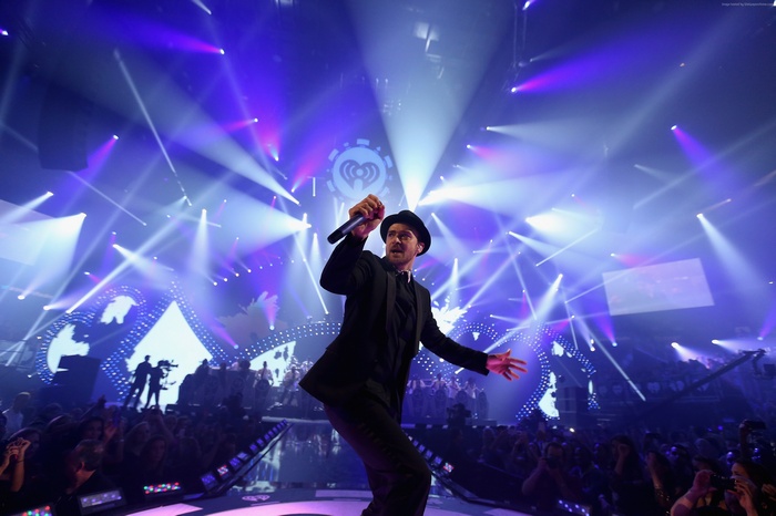 Justin Timberlake performing on stage with iHeartRadio logo