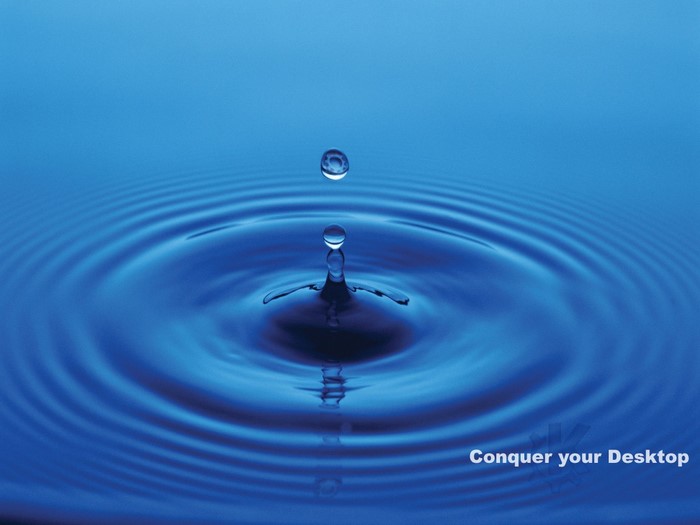 Water drop creating ripples on blue surface