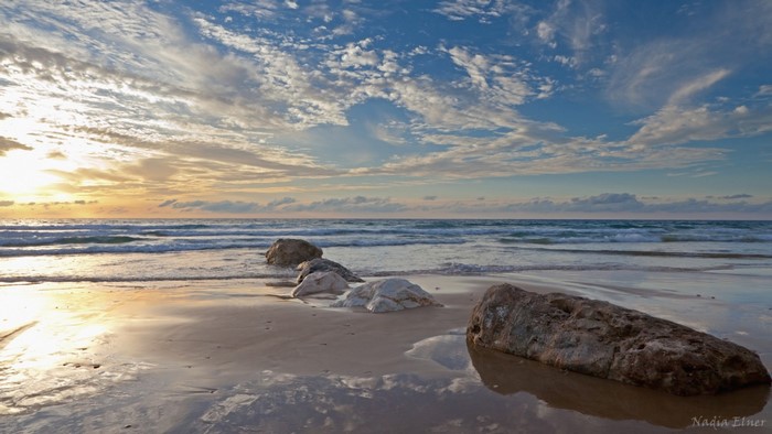 Beach with rocks and ocean at sunset