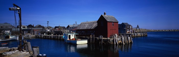 Fishing village with red building and boats in harbor