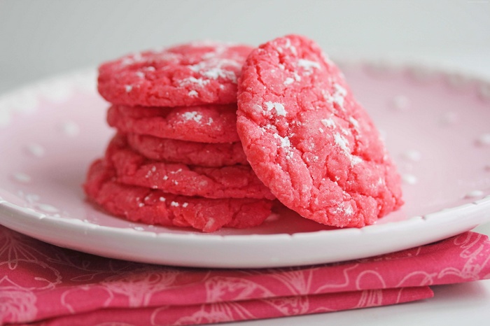 Pink cookies dusted with powdered sugar on a plate
