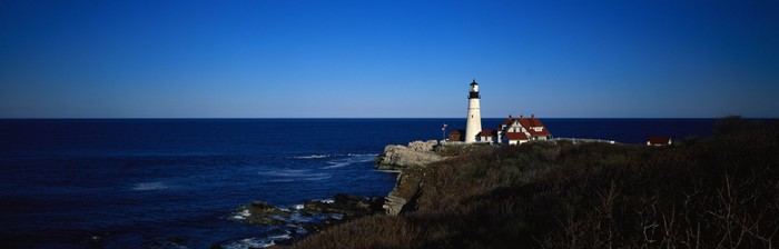 Portland Head Light lighthouse on a rocky coast at dusk