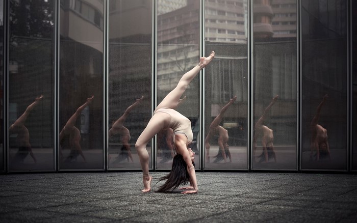 Dancer performing a bridge pose with reflections