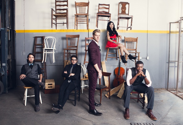 Pentatonix members posing in a garage with chairs