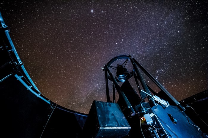 Telescope under a starry night sky