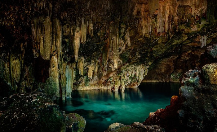 Mystical Cave with Turquoise Water and Stalactites