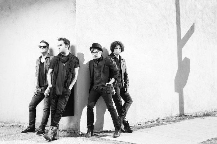 Fall Out Boy band members posing against a wall