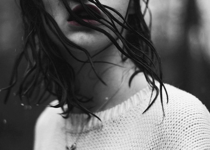 Monochrome close-up of a woman with wet hair and red lips