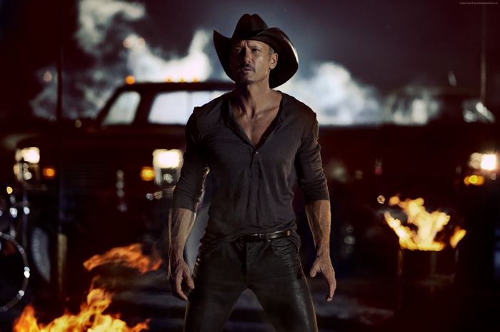 Tim McGraw in a cowboy hat with fires and trucks