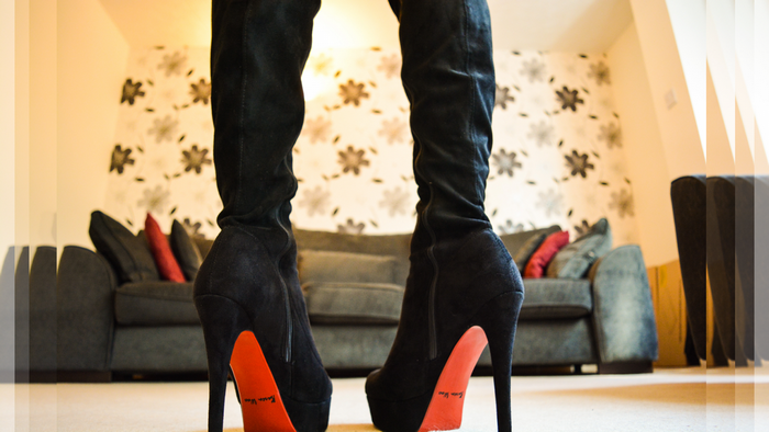 Woman wearing black knee-high platform boots with red soles
