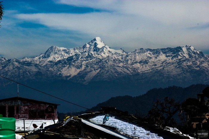 Snow-capped Himalayas over village rooftops