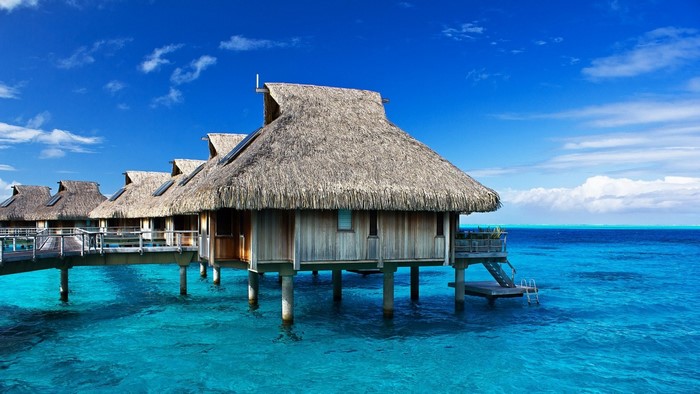 Overwater bungalows in a tropical turquoise lagoon