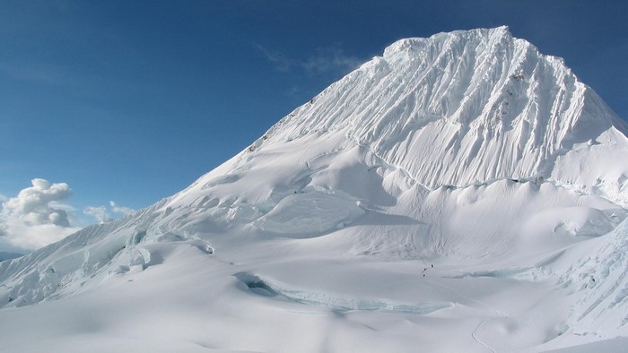 Snowy mountain range with skiers