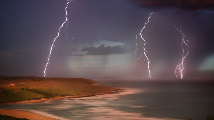 Lightning strikes over a coastal landscape during a storm