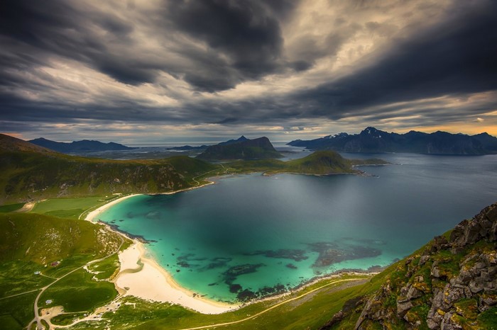Scenic bay with mountains under dramatic clouds in Norway