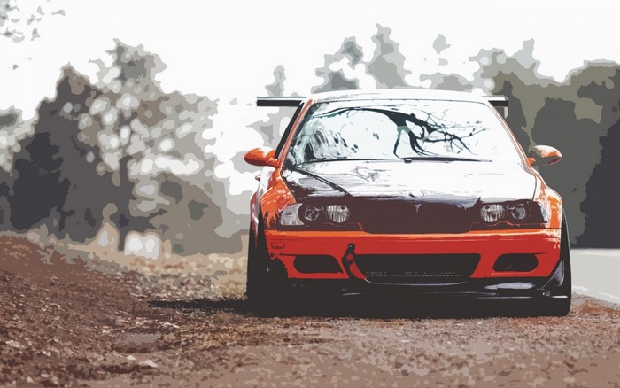 Orange sports car with a spoiler on a dirt road