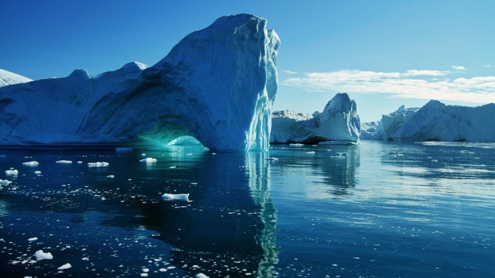Icebergs floating in the Arctic ocean under a clear blue sky