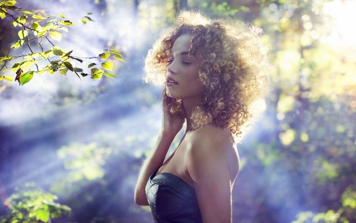 Rose Bertram in a forest with sunlight