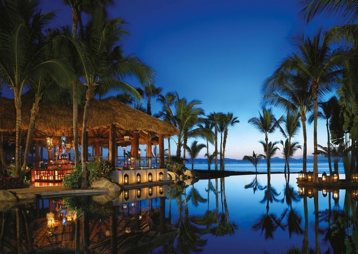 Tropical resort bar with infinity pool at dusk