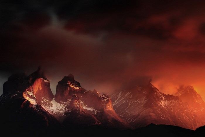 Torres del Paine mountains at sunrise with red clouds