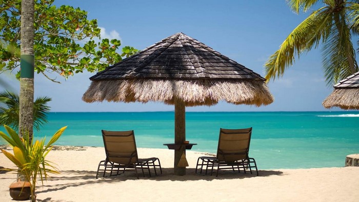 Tropical beach with lounge chairs and umbrellas