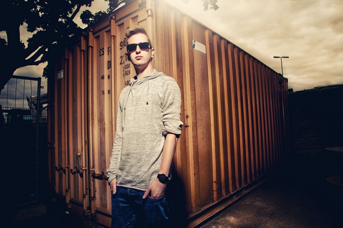 Robin Schulz standing by a shipping container