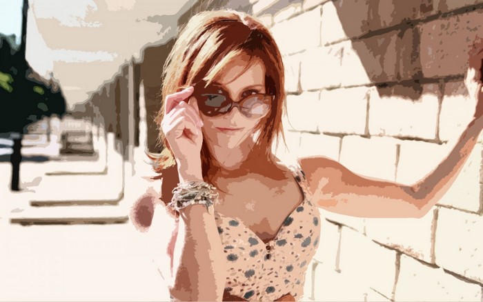 Woman with sunglasses leaning against a brick wall