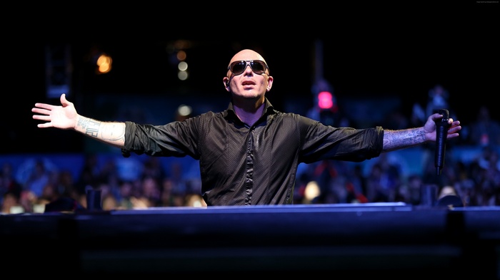 Pitbull performing on stage with a microphone