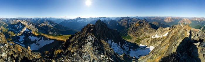 Panoramic view of a mountain range with snow and sunlight