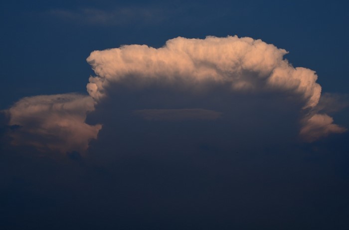 Cumulus clouds illuminated by sunlight against a dark sky