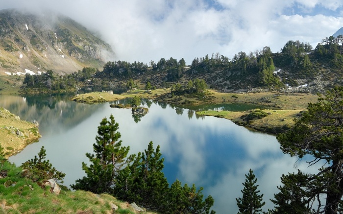 Mountain lake with trees and clouds