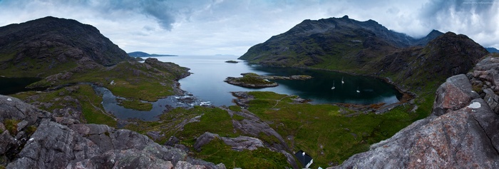 Panoramic view of a Scottish loch with mountains and boats