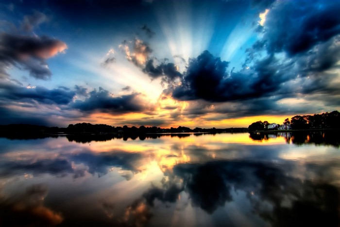 Sunset over a lake with sun rays and reflections