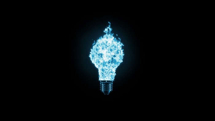 Blue flame lightbulb on black background