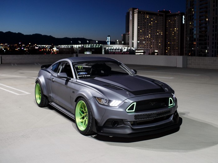 Modified Ford Mustang with neon green rims at night