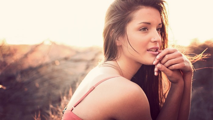 Woman with long brown hair and pierced nose