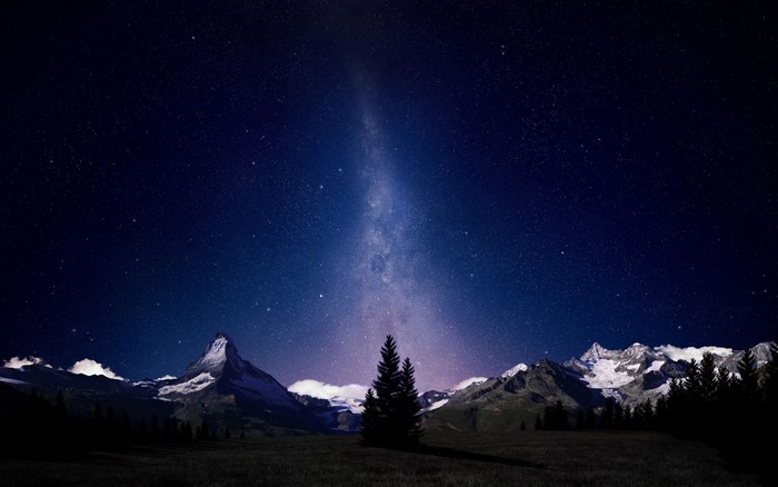 Milky Way over snow-capped mountains at night