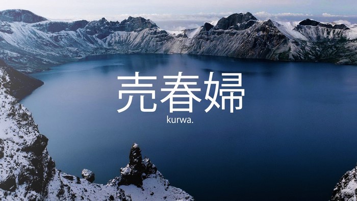 Crater lake with snow-capped mountains and Japanese text