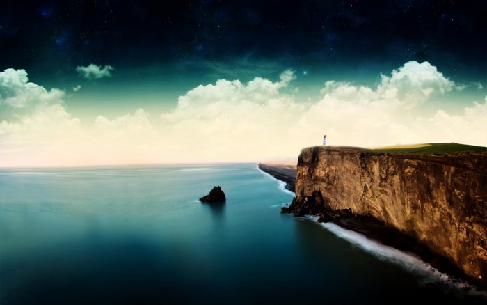 Cliff with lighthouse overlooking the sea at dusk