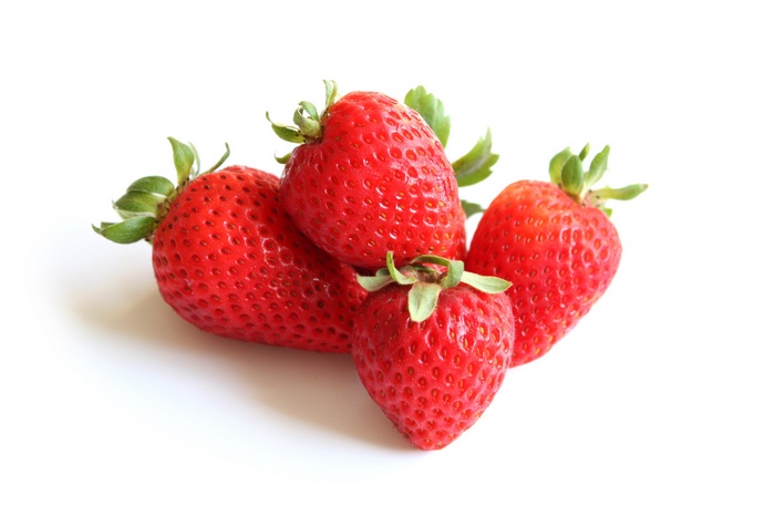 Four ripe strawberries on a white background