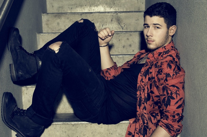 Nick Jonas sitting on stairs