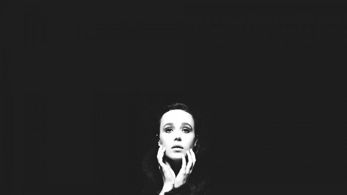 Monochrome portrait of Ellen Page with hands on face