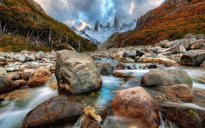 Mountain river with rocky banks and jagged peaks