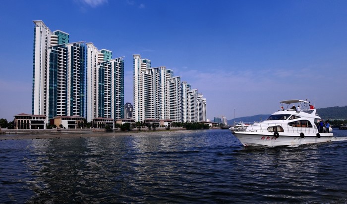 Modern high-rise buildings and a yacht on the water