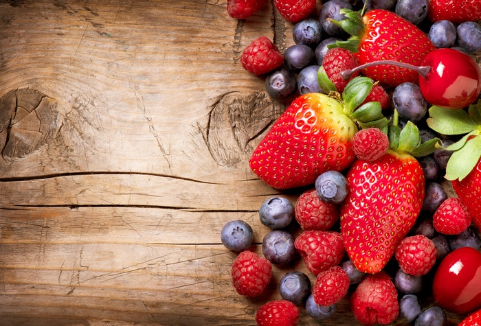Assortment of fresh berries on a wooden surface