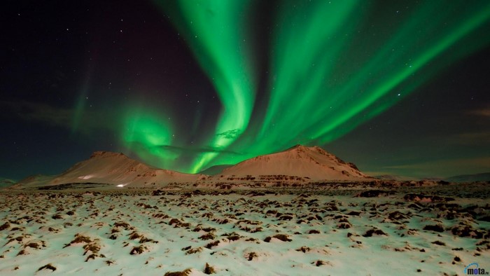 Aurora Borealis over snowy mountains and landscape