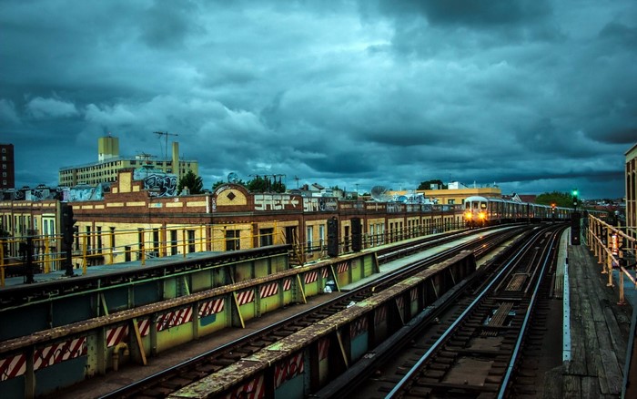 Elevated Train Tracks and Buildings Under Cloudy Sky