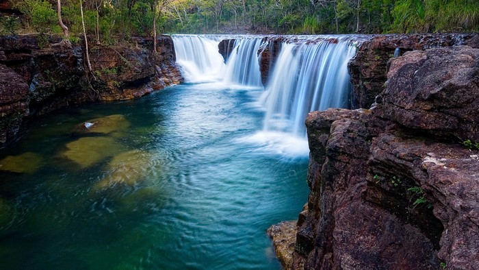 Waterfall cascading over rocks into a turquoise pool